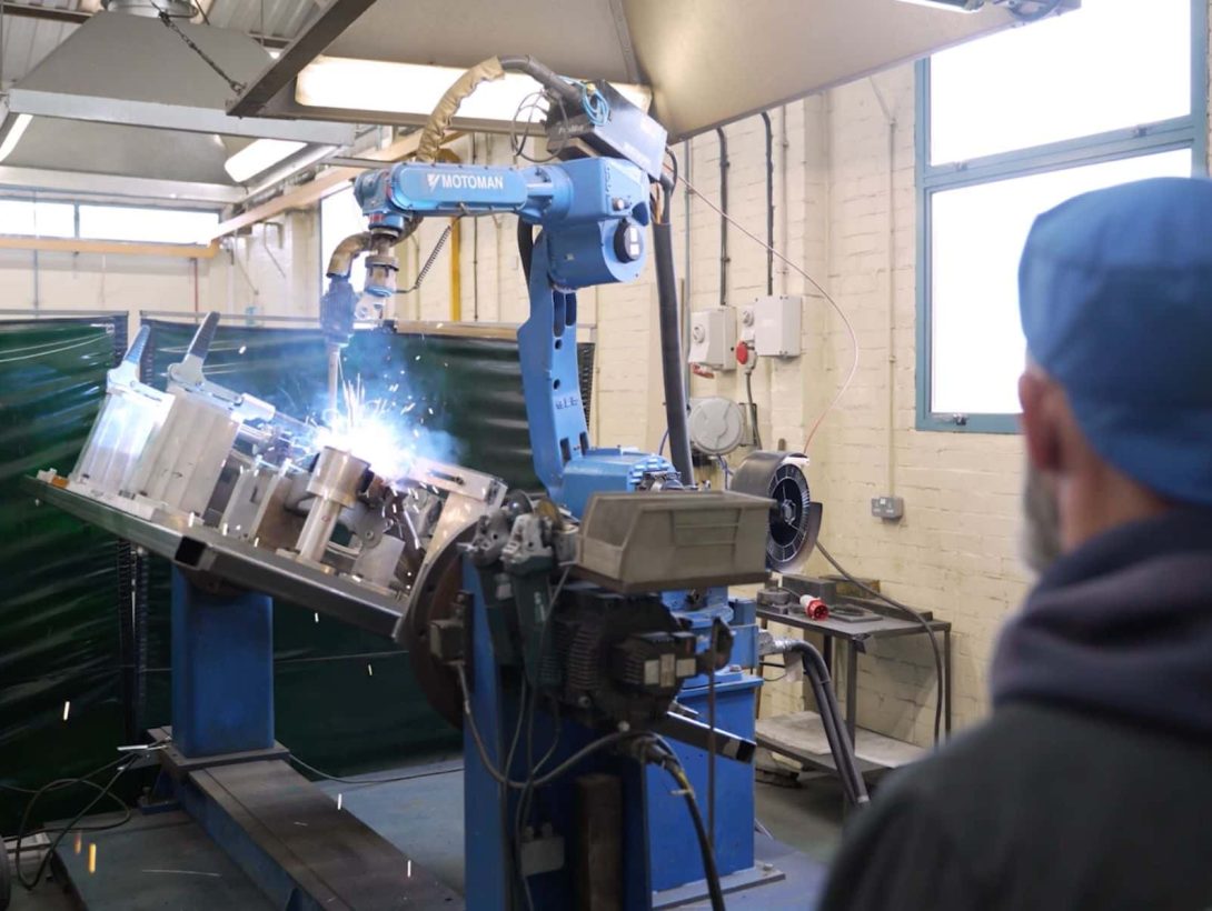 Robotic welding cell assembling metal components with automated Motoman welder